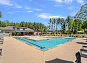 Thumbnail 11 of 54 - A large swimming pool surrounded by trees and a building.