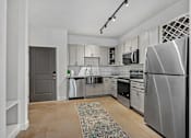 Thumbnail 21 of 52 - A modern kitchen with stainless steel appliances and a rug on the floor.