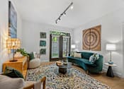 Thumbnail 25 of 54 - A living room with a green couch and a rug.