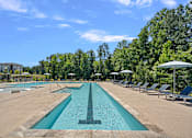 Thumbnail 8 of 54 - A large swimming pool with a diving board in the middle.
