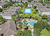 Thumbnail 14 of 27 - A bird's eye view of a residential area with a swimming pool surrounded by houses.