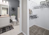 Thumbnail 26 of 27 - View with a bathroom with a toilet and sink plus the closet with hangers.