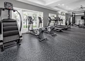 Thumbnail 7 of 27 - A spacious fitness center with treadmills, elliptical machines, and other exercise equipment.