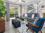 Thumbnail 20 of 27 - A living room with a grey couch, a blue chair, tv, and large window with curtains.