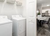 Thumbnail 27 of 27 - A white washing machine and dryer side by side in a laundry room.