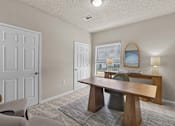 Thumbnail 8 of 19 - A room with a table, chairs, and a window at Heights at New Garden apartments in Greensboro, NC.