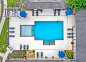 Thumbnail 2 of 14 - A large swimming pool surrounded by lounge chairs and umbrellas.