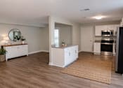 Thumbnail 4 of 15 - A modern kitchen with white cabinets and a wooden floor.