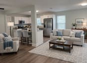 Thumbnail 6 of 15 - A modern kitchen with a dining area and a living room.