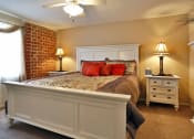 Thumbnail 19 of 20 - a bedroom with a bed and a brick wall
