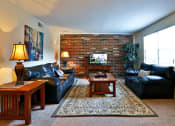 Thumbnail 17 of 20 - a living room with leather furniture and a brick wall