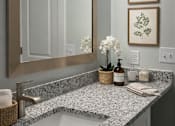 Thumbnail 10 of 15 - A bathroom with a marble countertop and a large mirror above the sink.