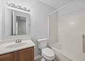 Thumbnail 18 of 52 - A white bathroom with a toilet, sink, and bathtub.
