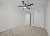 Thumbnail 46 of 52 - Bedroom with a ceiling fan, carpeted floor and closed closet doors.