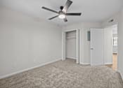 Thumbnail 43 of 52 - Bedroom with a ceiling fan, carpeted flooring and an open closet.