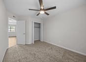 Thumbnail 44 of 52 - Bedroom with a ceiling fan, carpeted flooring and an open closet door.