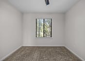 Thumbnail 39 of 52 - A bedroom with a carpeted floor and a window with blinds.