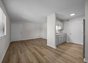 Thumbnail 31 of 52 - Kitchen area with white cabinets and wooden floors.