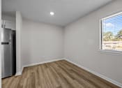 Thumbnail 8 of 52 - A room with a window and a wooden flooring plus the side of the refrigerator.