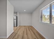 Thumbnail 6 of 52 - A long room with wooden floors and a window with blinds.