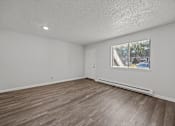 Thumbnail 34 of 52 - Open room with wooden flooring and a large window.
