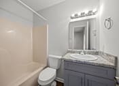 Thumbnail 19 of 52 - A bathroom with a toilet, sink, and mirror.