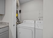 Thumbnail 15 of 52 - A laundry room with a white washer and dryer.