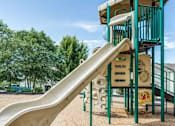 Thumbnail 2 of 20 - A playground with a slide and a climbing structure.