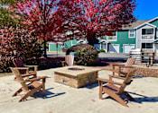 Thumbnail 4 of 20 - Two chairs and a table are in the foreground of a sunny patio.