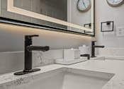 Thumbnail 15 of 17 - A modern bathroom with a marble countertop and a large mirror above the sink.