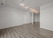 Thumbnail 13 of 17 - A room with wooden flooring and white walls.