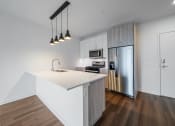 Thumbnail 29 of 34 - a kitchen with an island and stainless steel refrigerator