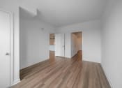 Thumbnail 30 of 34 - a living room and kitchen with white walls and wood floors