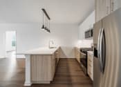 Thumbnail 21 of 34 - a kitchen with a large island and stainless steel appliances