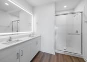 Thumbnail 28 of 34 - a white bathroom with two sinks and a shower
