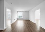 Thumbnail 22 of 34 - an empty living room with white walls and wood floors