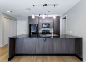 Thumbnail 37 of 41 - a kitchen with dark wood cabinets and a large island with a black countertop