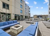 Thumbnail 11 of 33 - a seating area with couches and chairs on a patio with tables and chairs in the background at Lakeview 3200 Apartments, Chicago, 60657