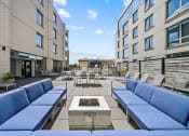 Thumbnail 3 of 33 - a seating area with couches and chairs on a patio with a fire pit in the middle at Lakeview 3200 Apartments, Chicago, IL