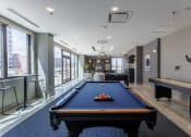 Thumbnail 33 of 41 - a pool table and ping pong table in a games room with a view of the city