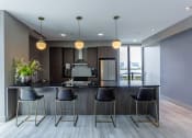 Thumbnail 32 of 41 - a kitchen with a large island with stools in front of it