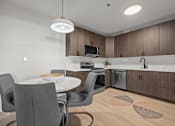 Thumbnail 5 of 17 - A modern kitchen with a dining table and chairs.