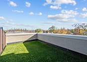 Thumbnail 17 of 17 - A small grassy area is surrounded by a concrete wall.