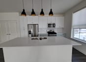 Thumbnail 14 of 14 - A kitchen with white cabinets and a large island.