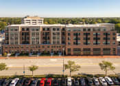 Thumbnail 15 of 34 - an aerial view of a parking lot with cars in front of a building