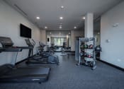 Thumbnail 13 of 34 - a gym with treadmills and other exercise equipment and a tv