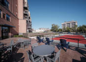 Thumbnail 11 of 34 - a patio with a table and chairs and a tennis court