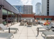 Thumbnail 28 of 41 - a large terrace with lounge chairs and tables on the top of a building