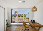 Thumbnail 13 of 52 - An office with a desk and a chair with a laptop on it at Fusion Hollywood Apartments.