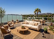 Thumbnail 14 of 52 - A private patio with a table and chairs overlooking a city at Fusion Hollywood Apartments.